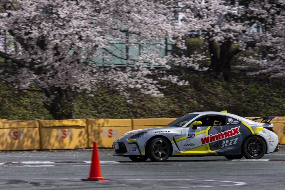 桜を背景に走行する競技車両